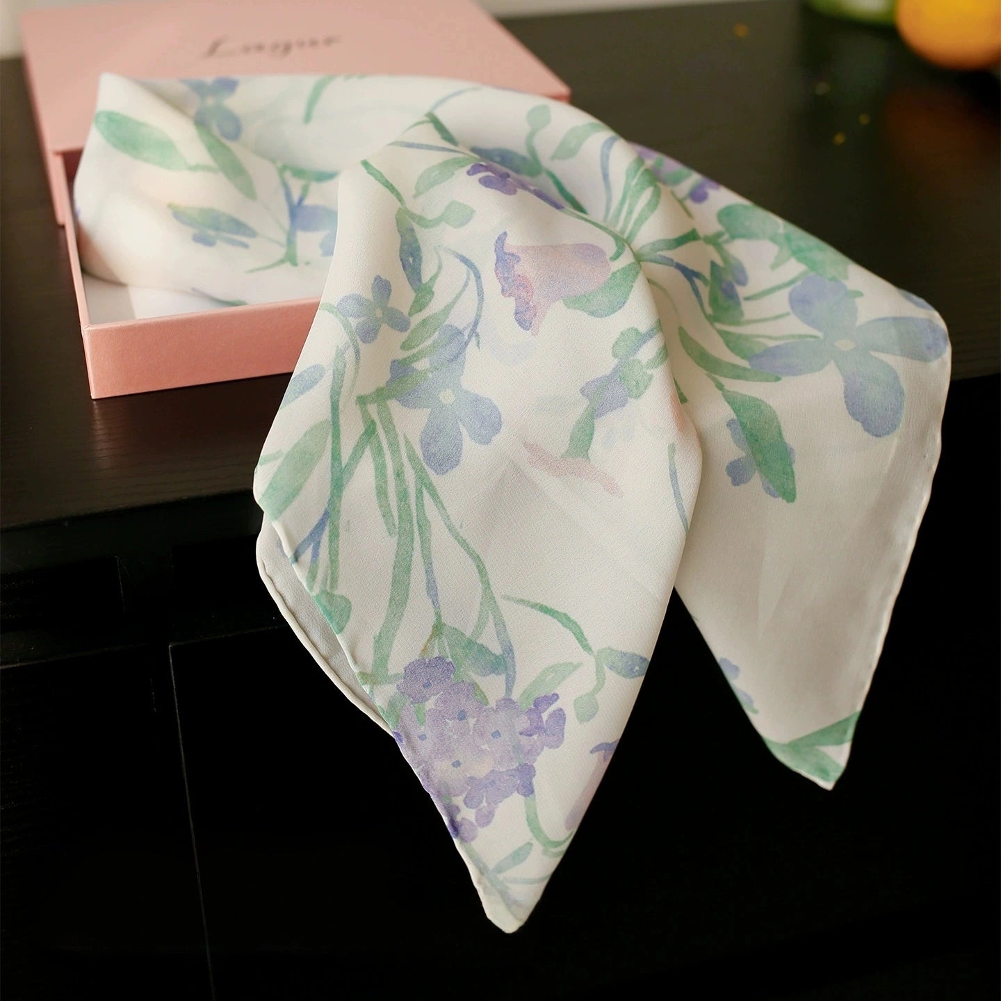 Watercolor floral silk scarf folded neatly, highlighting its lightweight and smooth texture.